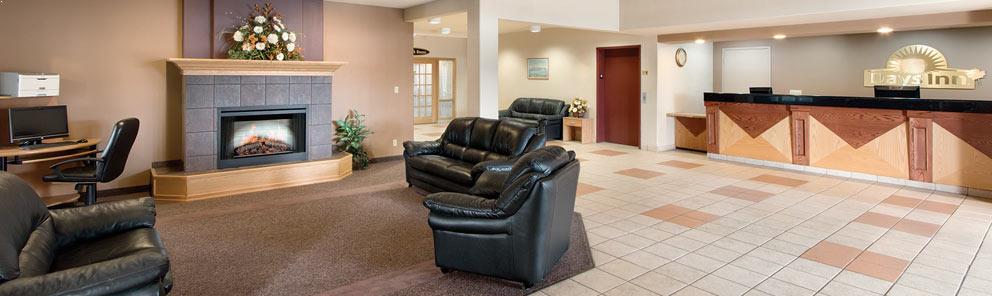 A spacious lobby with a fireplace and comfortable leather chairs at the Days Inn Hotel In Thunder Bay, Canada